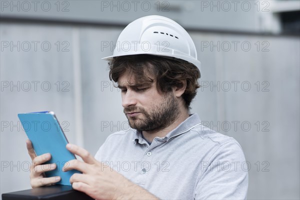 Technician with beard middle aged and working outside with polo shirt and helmet