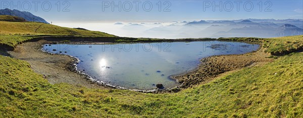 Small lake with the peaks of the Garda Mountains and Bergamo Alps