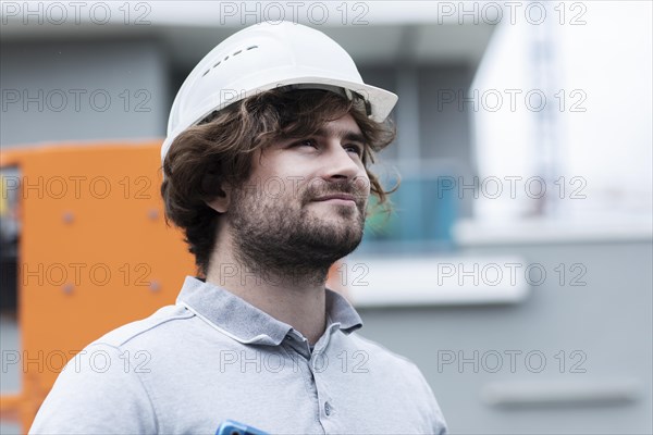 Technician with beard middle aged and working outside with polo shirt and helmet