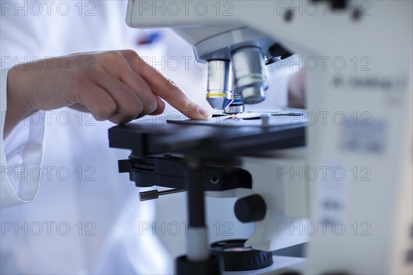 Hand of a lab technician with microscope