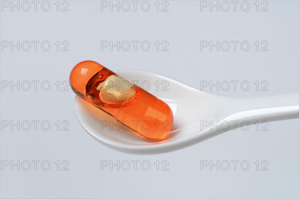 Capsule with omega-3 fatty acids in spoon