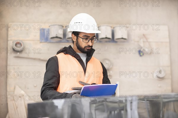 Technician with beard and helmet works in a workshop