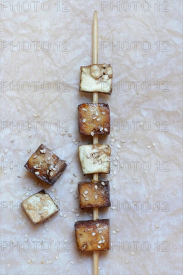 Fried tofu cubes on wooden skewer