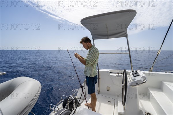 Young man fishing on a boat