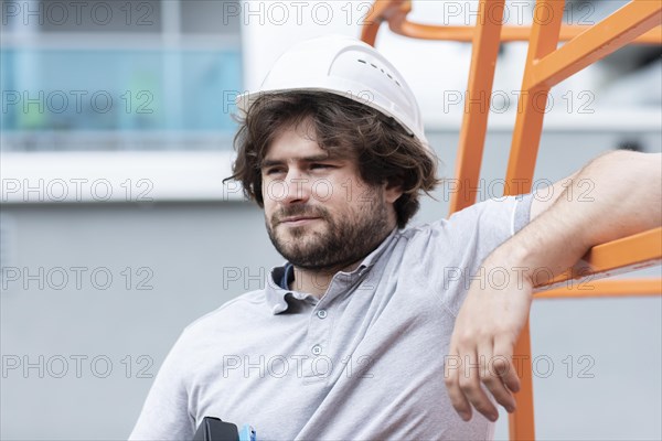 Technician with beard middle aged and working outside with polo shirt and helmet