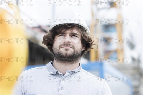 Technician with beard middle aged and working outside with polo shirt and helmet
