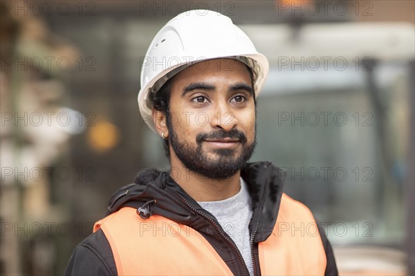 Technician with beard and helmet works in a workshop