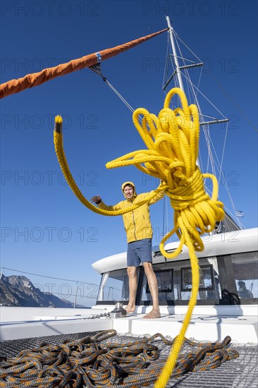 Sailor throws a yellow rope towards the camera