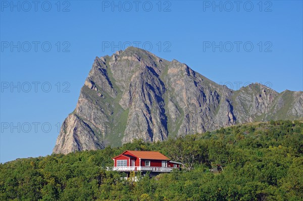 Lonely holiday home in front of rugged mountains