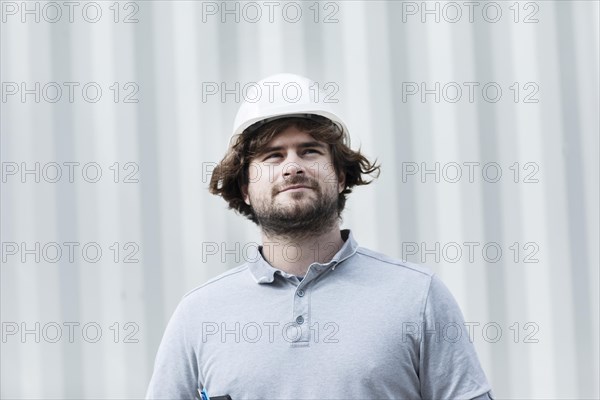 Technician with beard middle aged and working outside with polo shirt and helmet