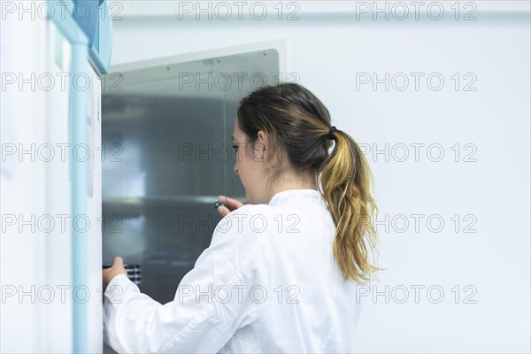 Petri dishes in the hand of a laboratory technician at the drying cabinet in the laboratory