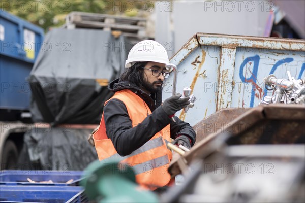 Technician with beard and helmet working in a recycling yard