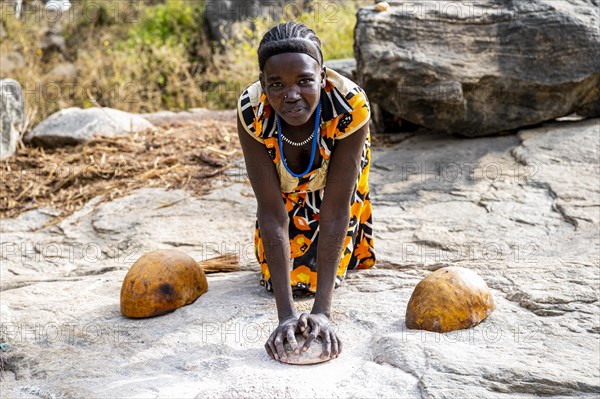 Young girls grinding Sorghum on a rock