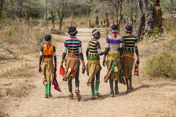 Traditional dressed young girls from the Laarim tribe from behind