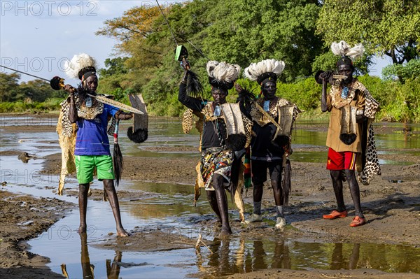 Men from the Toposa tribe posing in their traditional warrior costume