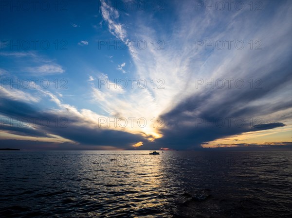Dark clouds over the sea in front of sunset