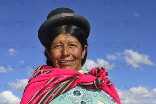 Older indigenous woman with hat smiling at the camera