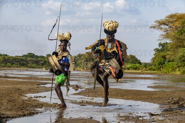 Men from the Toposa tribe posing in their traditional warrior costume