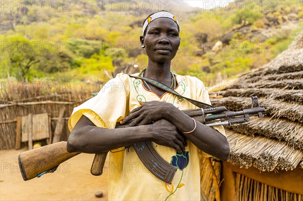 Woman carrying a Kalashnikov