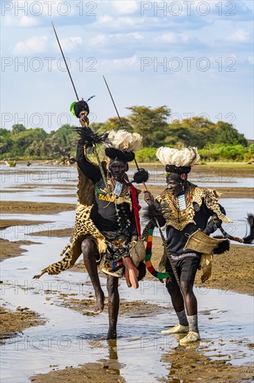 Men from the Toposa tribe posing in their traditional warrior costume