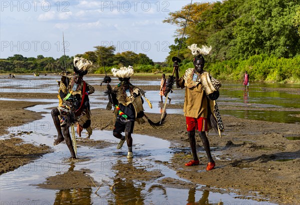 Men from the Toposa tribe posing in their traditional warrior costumes