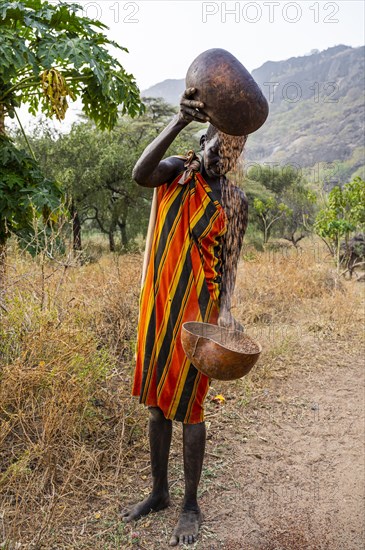 Laarim woman filtering Sorghum in a carabass