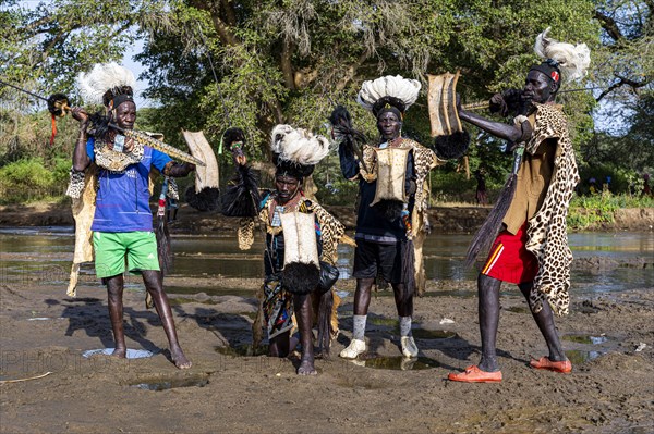 Men from the Toposa tribe posing in their traditional warrior costumes