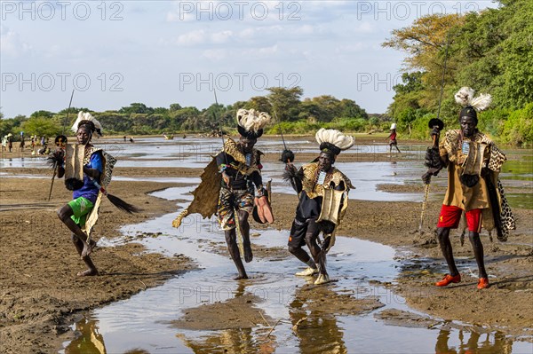 Men from the Toposa tribe posing in their traditional warrior costume