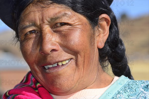 Older indigenous woman with hat smiling at the camera