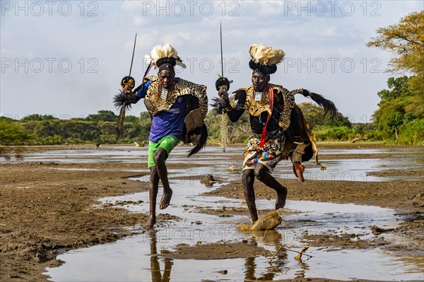 Men from the Toposa tribe posing in their traditional warrior costume