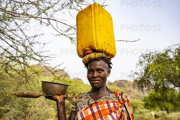 Woman with a water caniister on her head