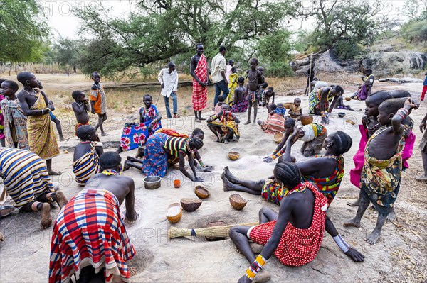 Young girls grinding Sorghum on a rock