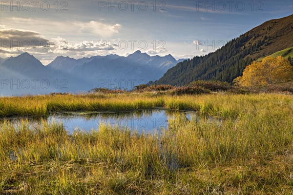 Autumn mountain landscape with small pond