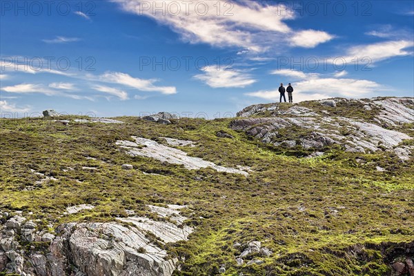 Walkers on rocky coast