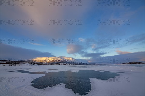 Frozen lake Tornetraesk with snow drifts