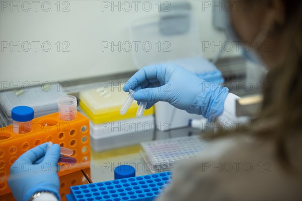 Medical laboratory assistant holding reaction vessels with samples