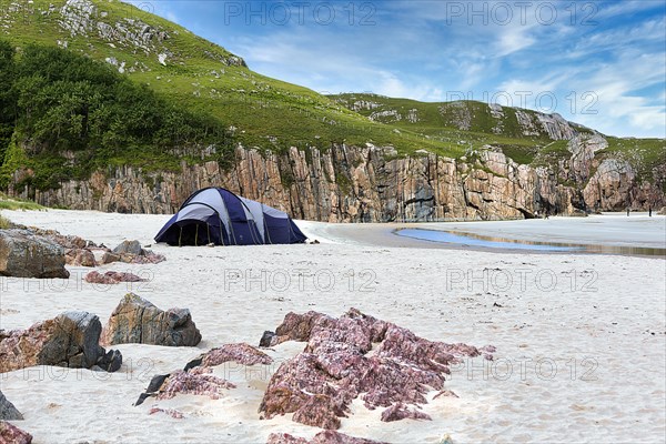 Tent in a bay with rocks and sandy beach