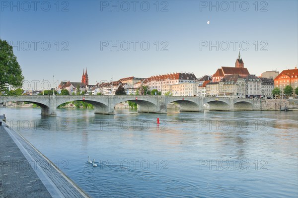 View from the banks of the Rhine along the river promenade to the old town of Basel with the Basel Cathedral