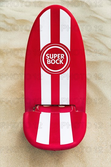 Red and white beach chair in the sand