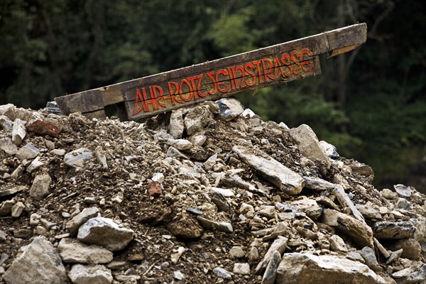 Sign Ahr-Rotweinstrasse protrudes from a mountain of rubble
