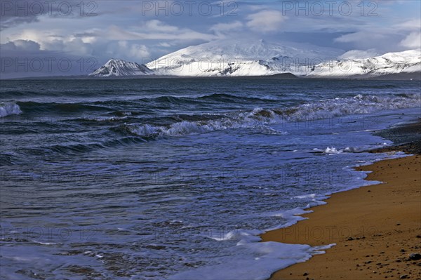 Beach with surf and the volcano and glacier Snaefellsjoekull