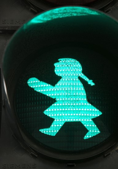 Pedestrian traffic light with green traffic light woman