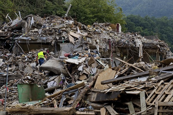 A man in mountains of rubble and rubbish