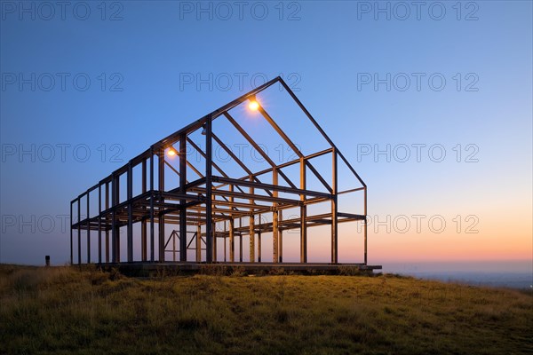 Illuminated hall house at sunrise on the North Germany slagheap