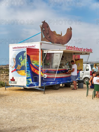 Customers at the food stall labelled Last Bratwurst in front of America