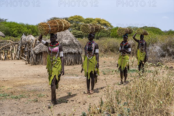 Girls with collected reeds on their heads on their way home