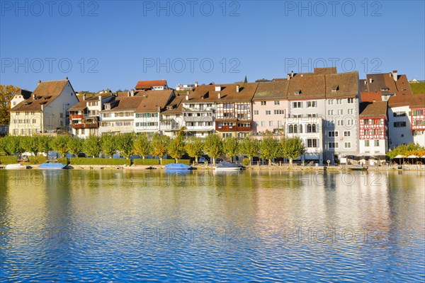 View from the banks of the Rhine over the Rhine towards the old town of Eglisau with reflection on the river water