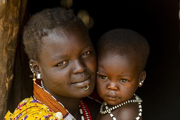 Woman with her baby sitting in a hut