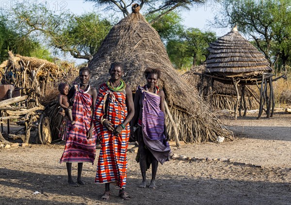 Older women from the Toposa tribe before their traditional hut
