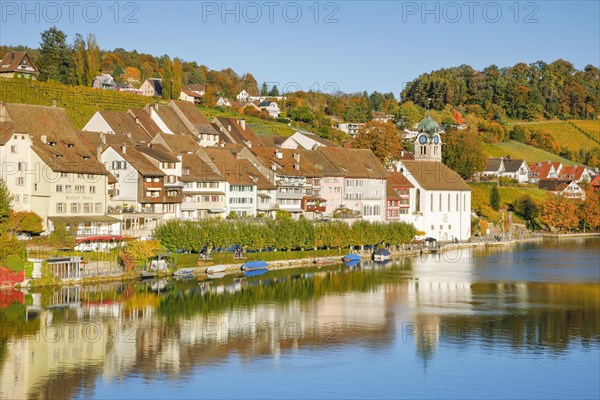 View from the Rhine bridge over the Rhine towards the old town of Eglisau with reflection on the river water